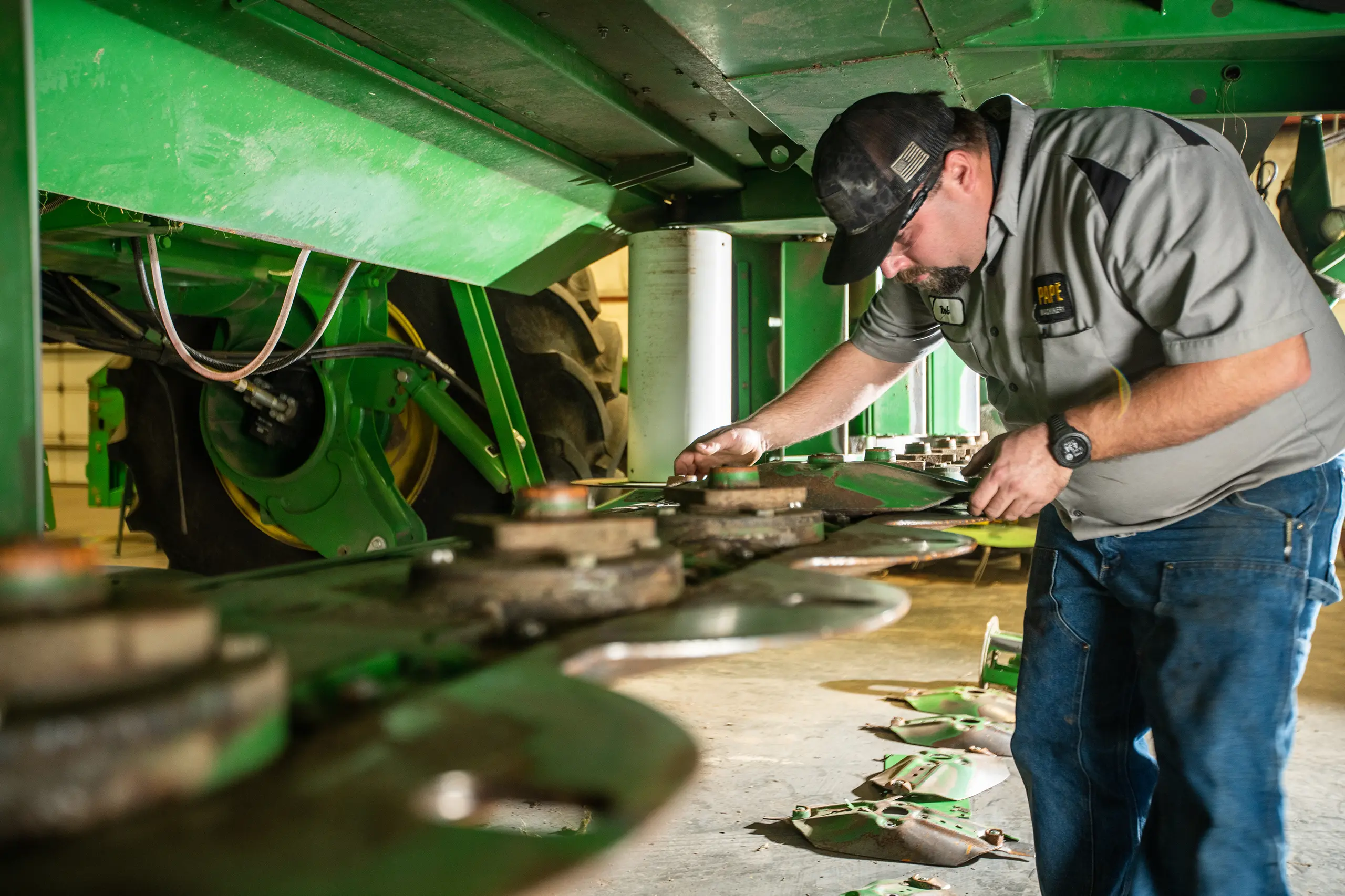 Papé technician inspecting rotary mower blades