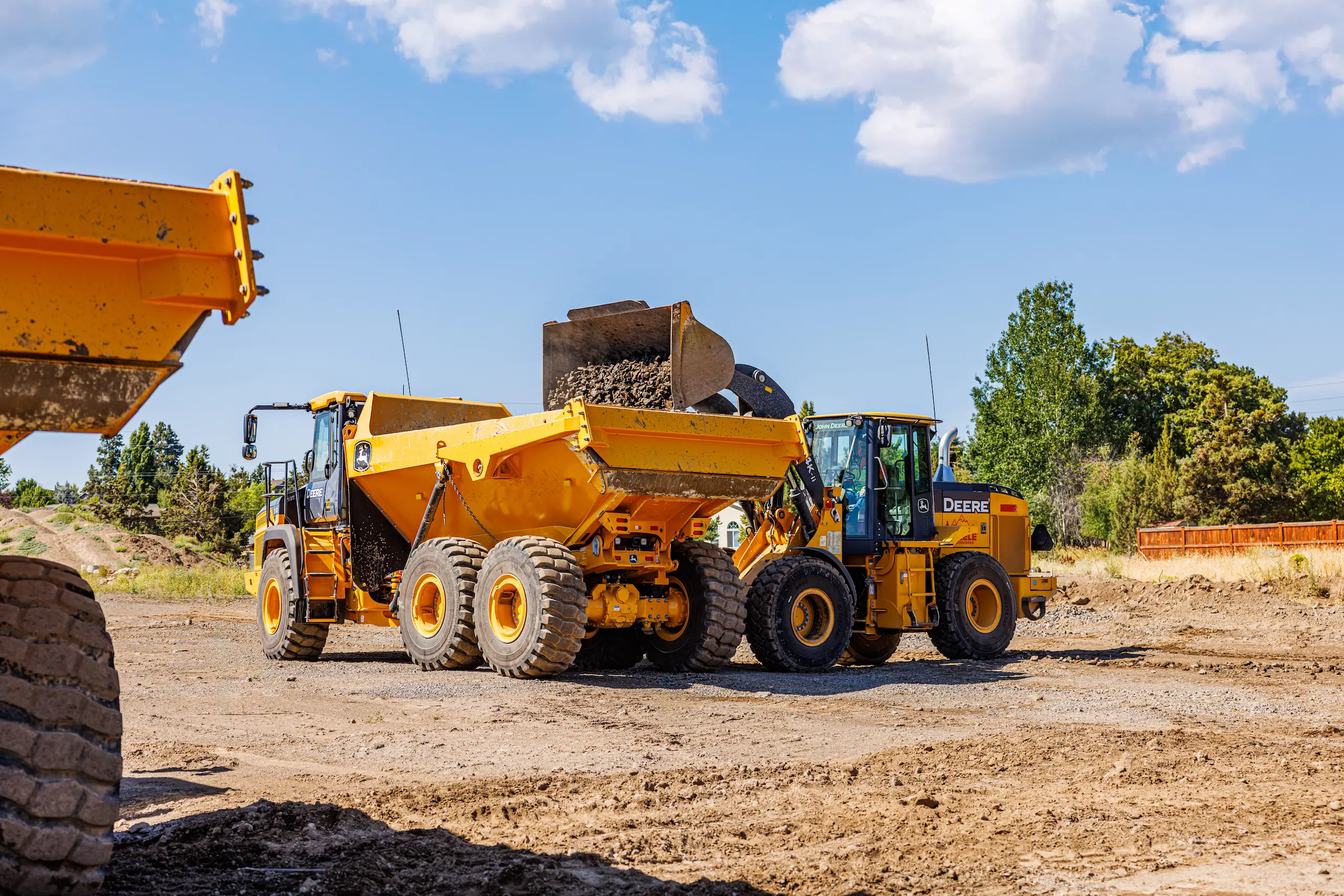 Wheel loader dumping gravel into hauler