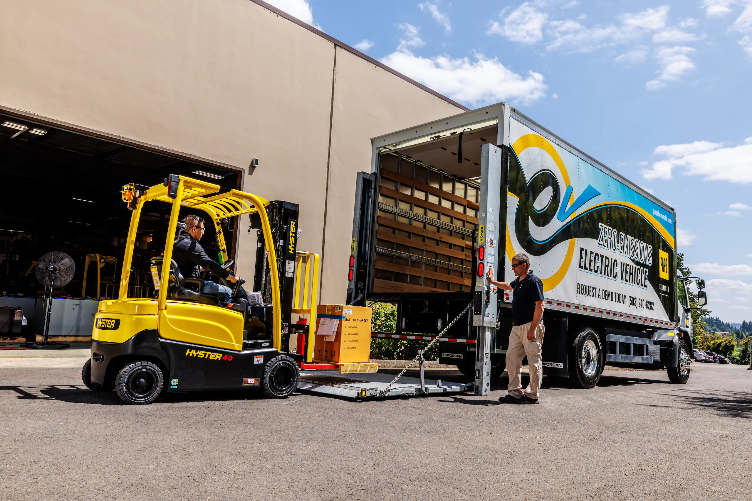 Forklift loading electric delivery truck outdoors