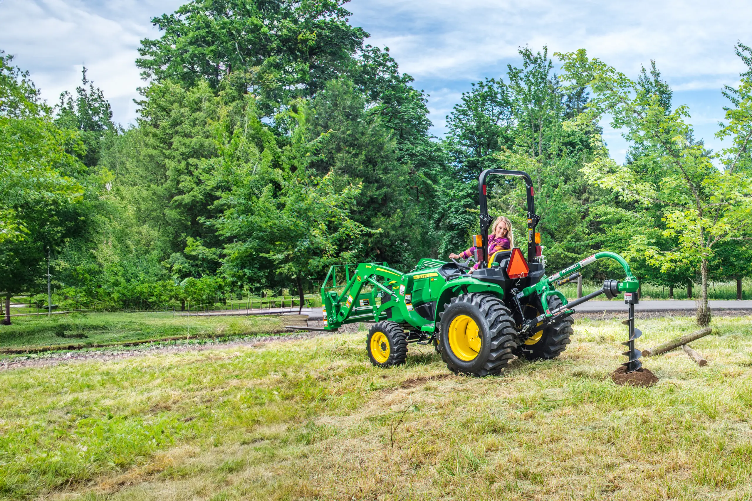 Woman driving John Deere tractor auger