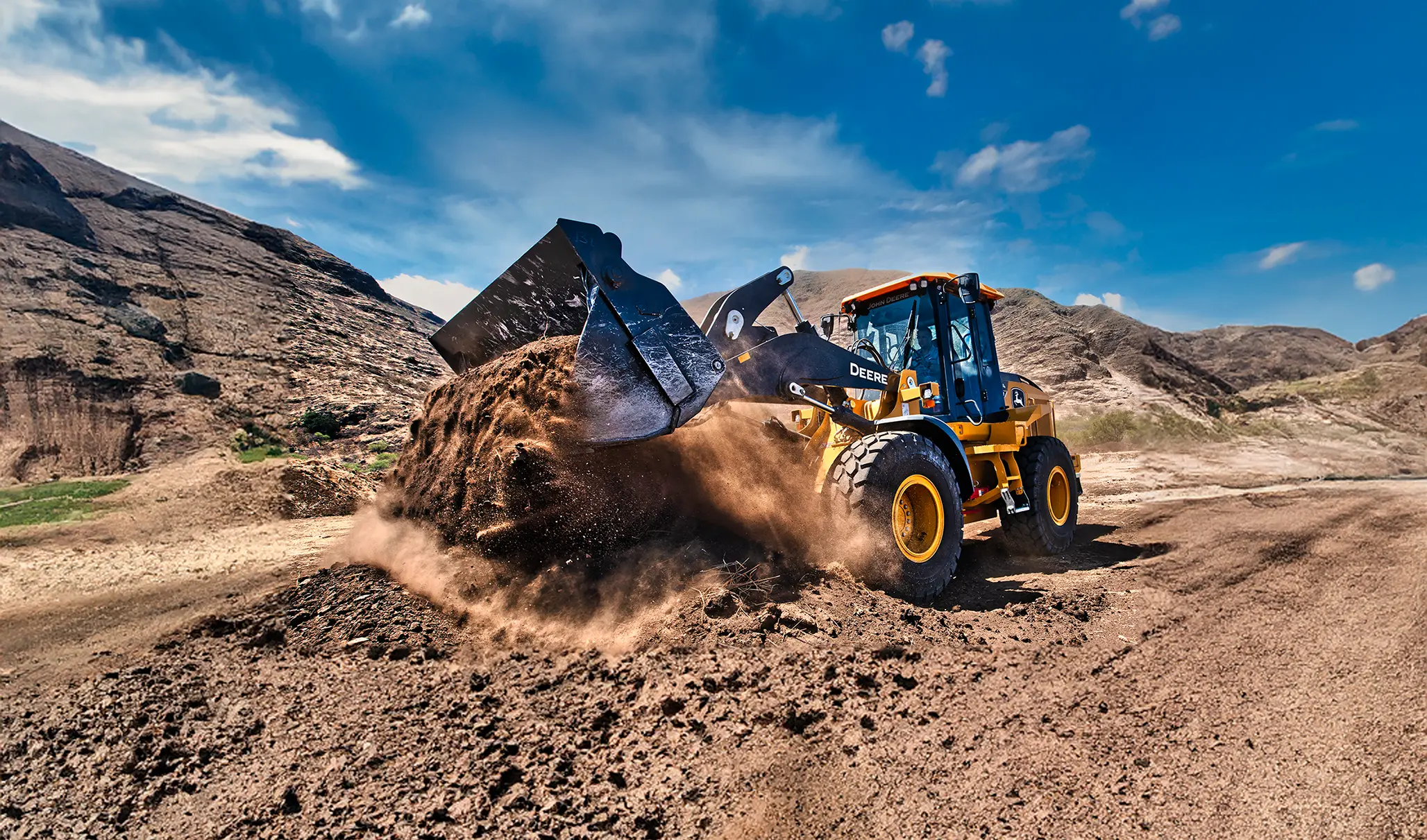 John Deere loader scooping dirt kicking dust