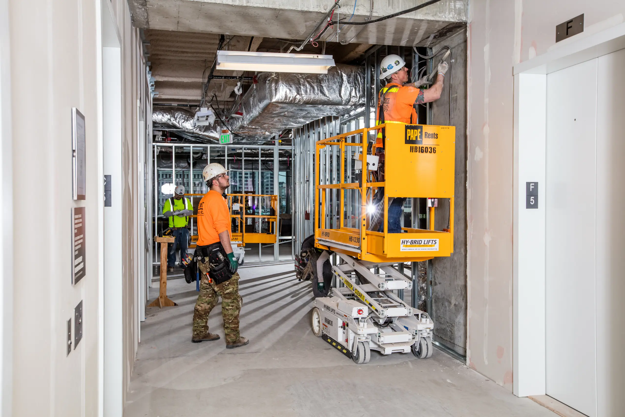 Workers on Papé Rents lift indoors