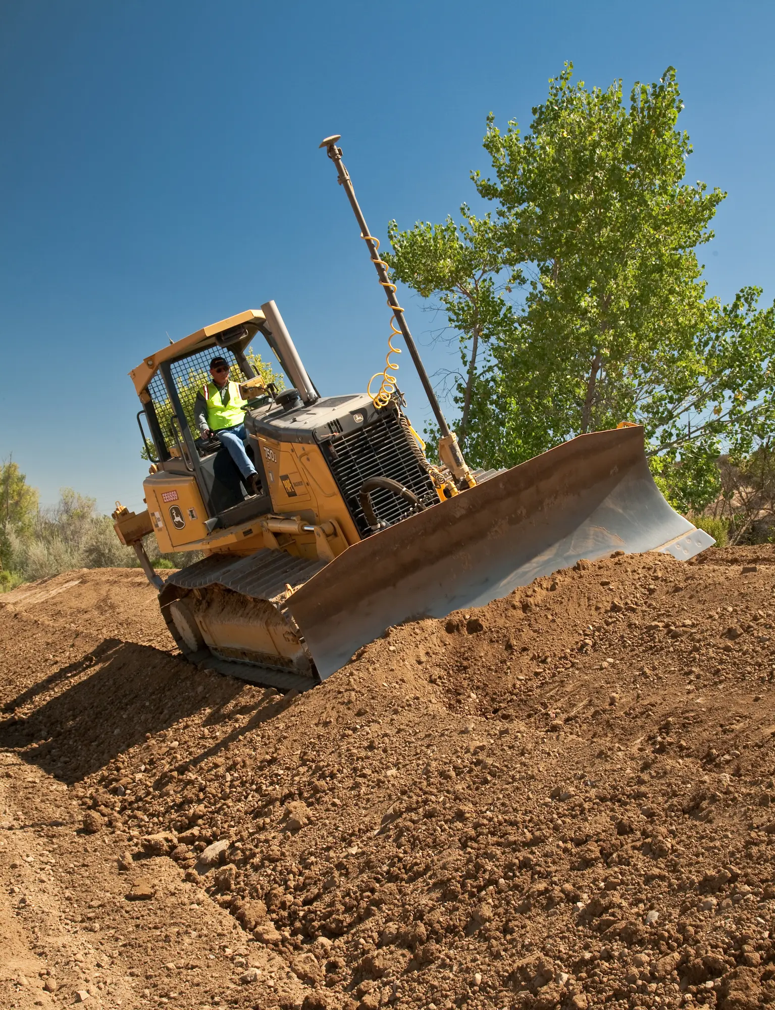Bulldozer grading dirt on hillside