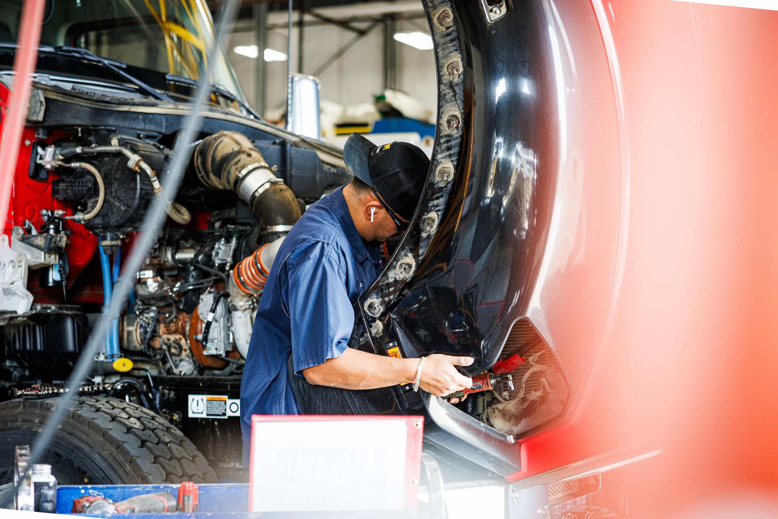 Mechanic repairing truck fender assembly