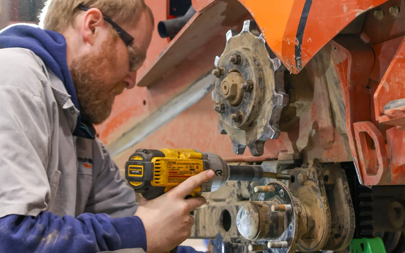 Technician using impact wrench on machinery