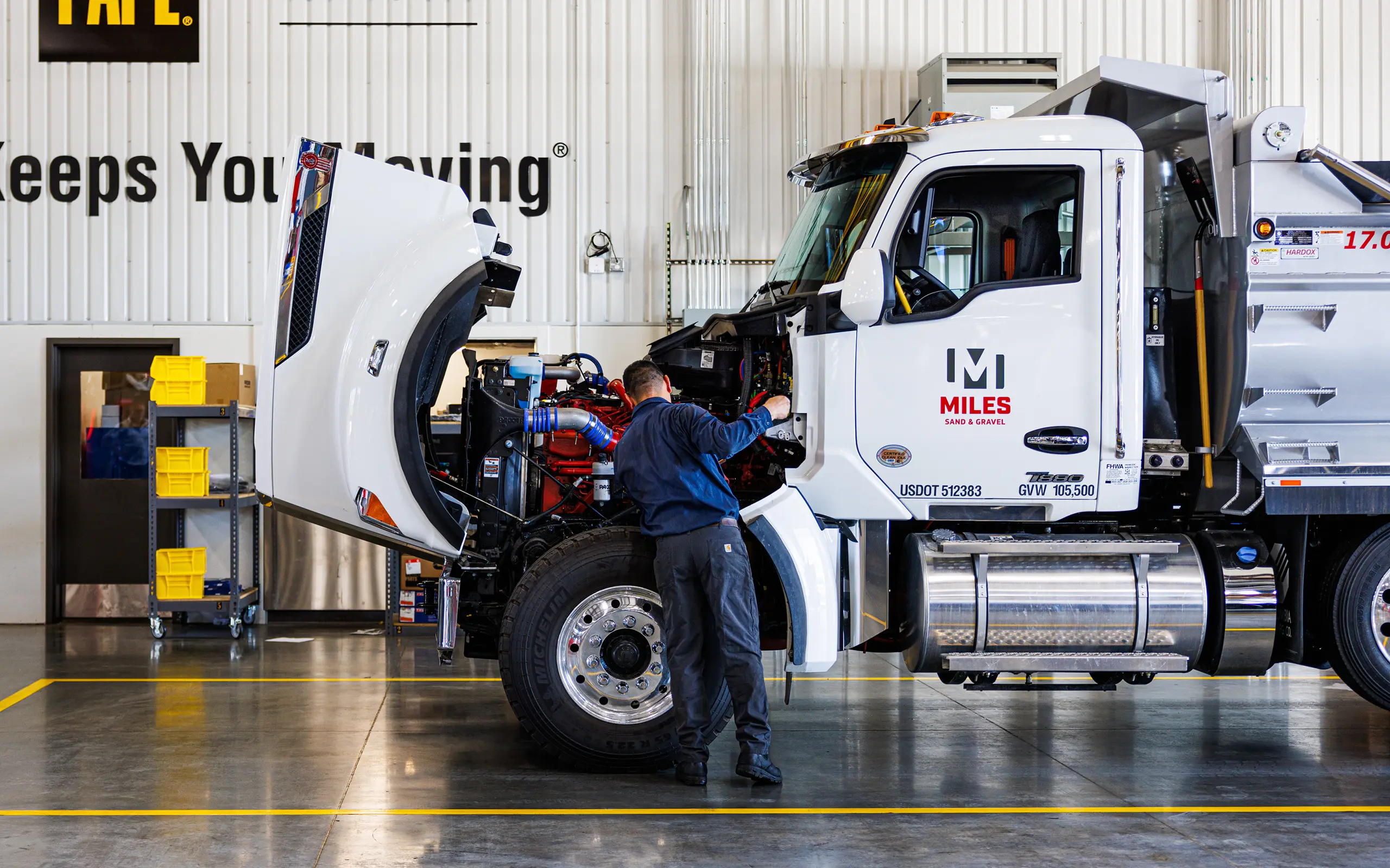 Technician repairing dump truck engine