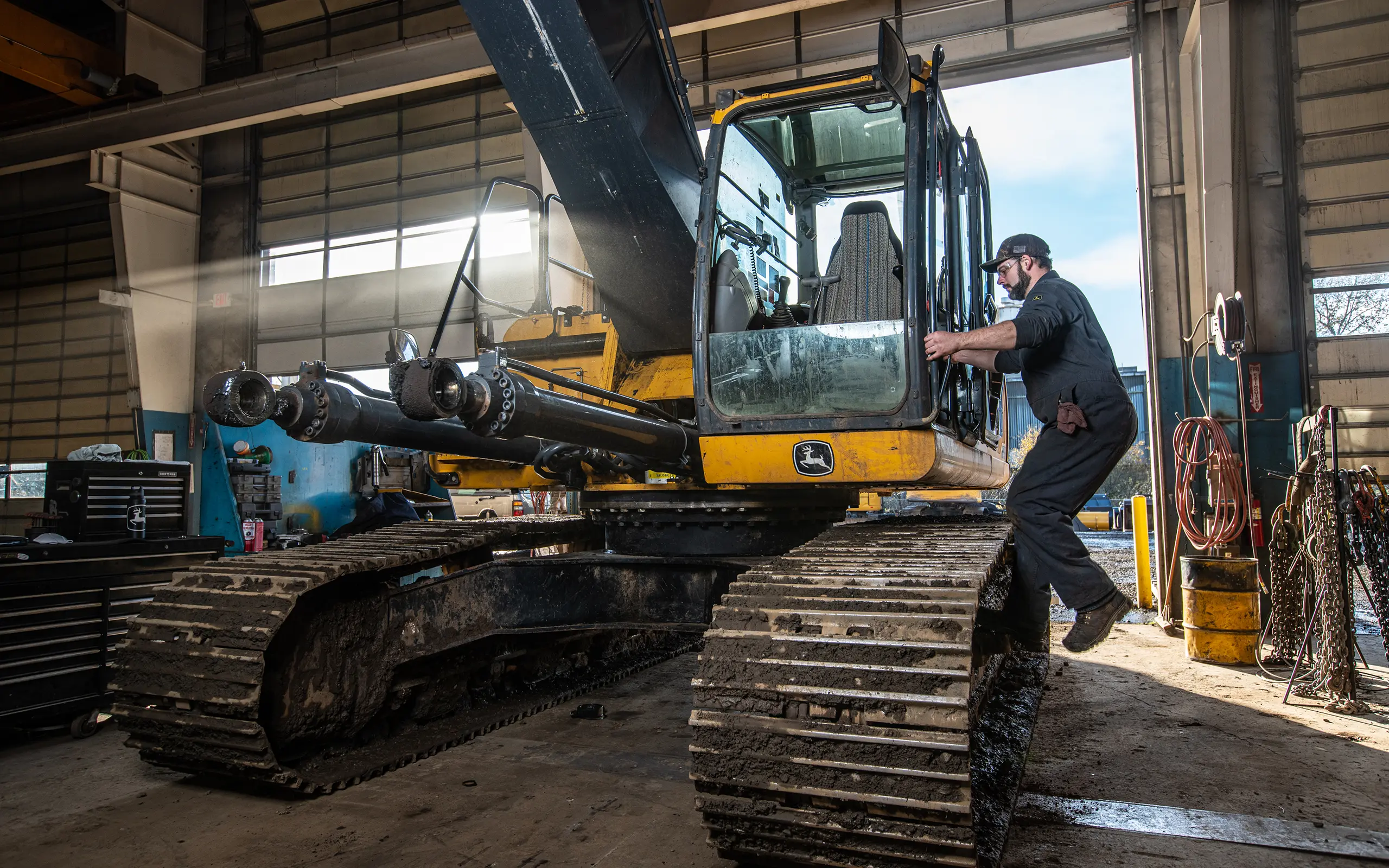 Technician servicing excavator in repair shop