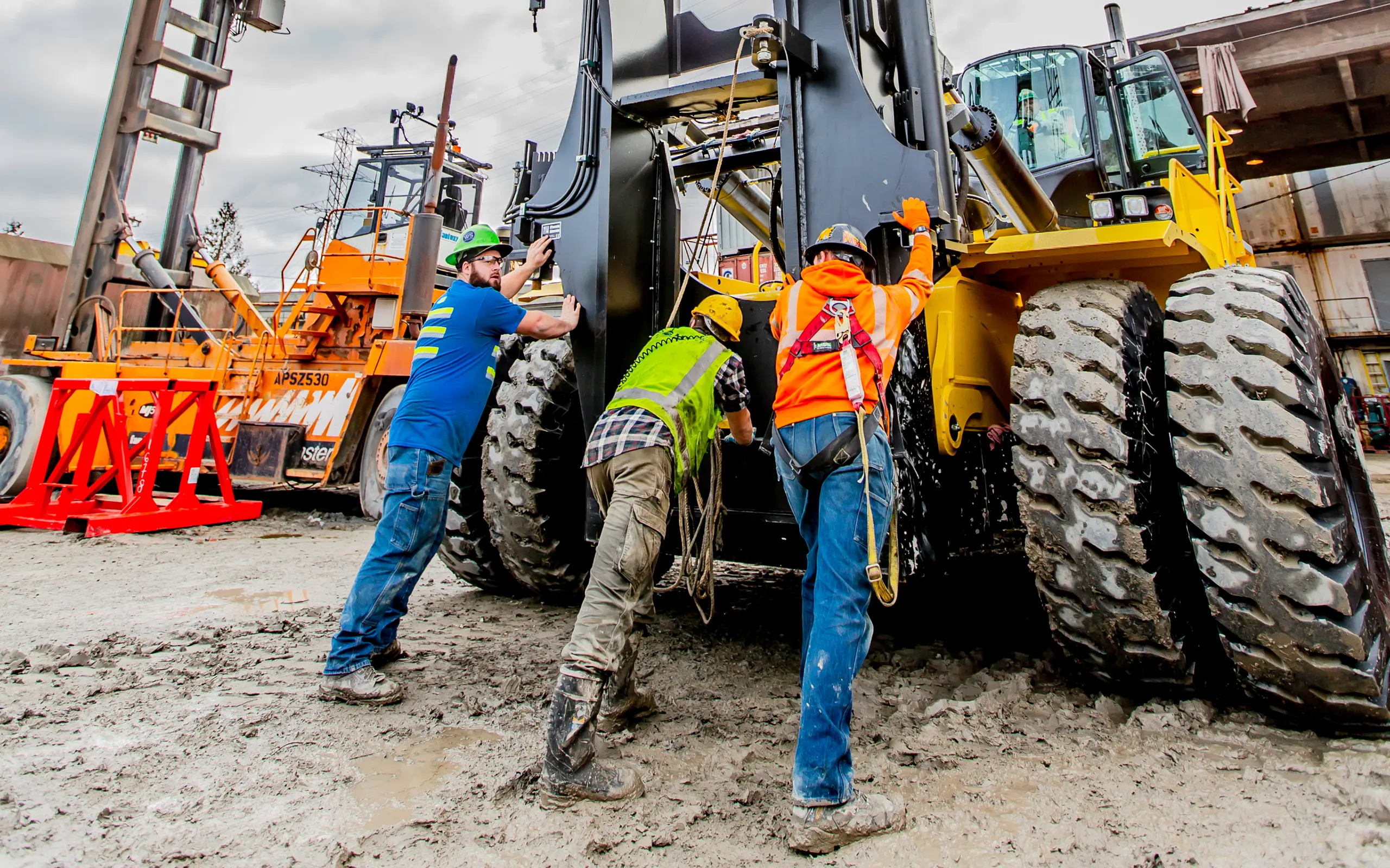 Crew servicing large machine in mud