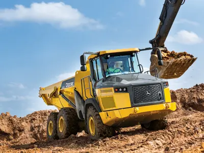 Excavator loading John Deere dump truck