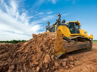 Bulldozer pushing large mound of dirt