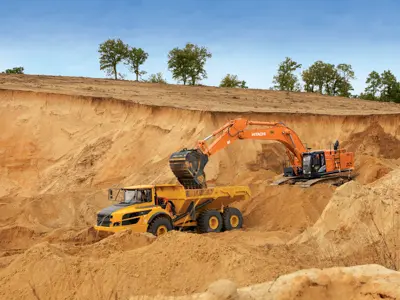 Excavator loading sand into dump truck