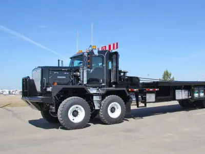 Black heavy-duty truck with flatbed trailer
