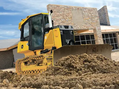 John Deere dozer pushing dirt outside