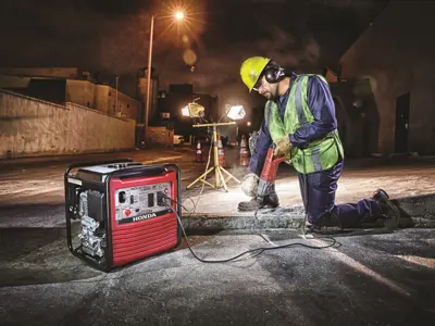 Worker using jackhammer at night site