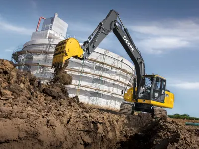 John Deere excavator near building construction