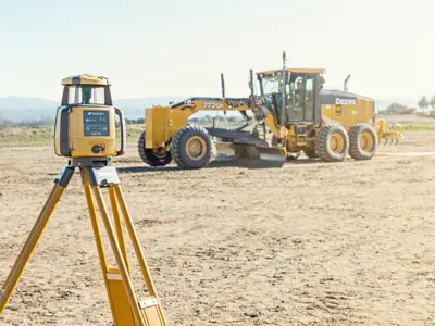 Survey equipment with grader in background
