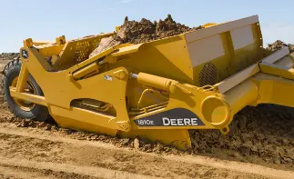John Deere scraper hauling loaded dirt