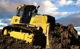 John Deere bulldozer pushing dirt pile